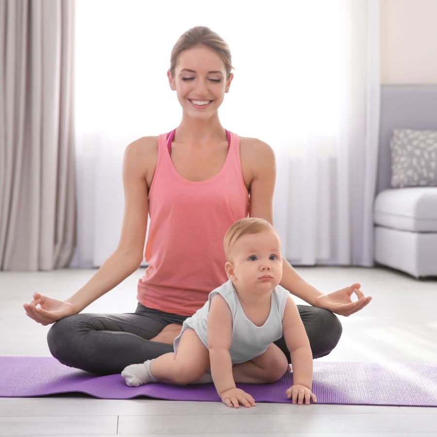 Mother doing postnatal yoga with her baby